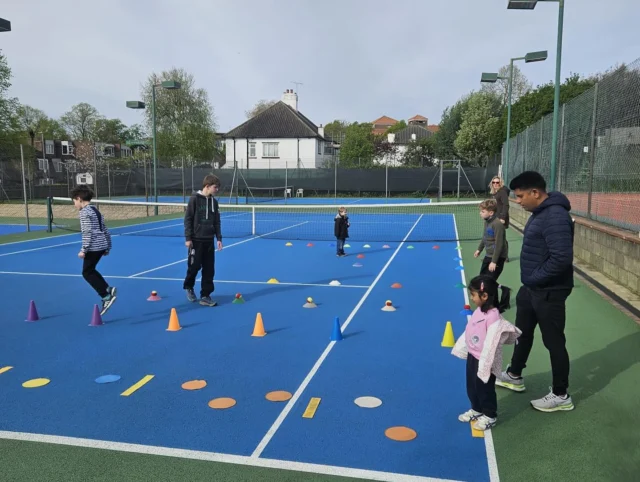 Junior players practising on court at Southfields Lawn Tennis Club